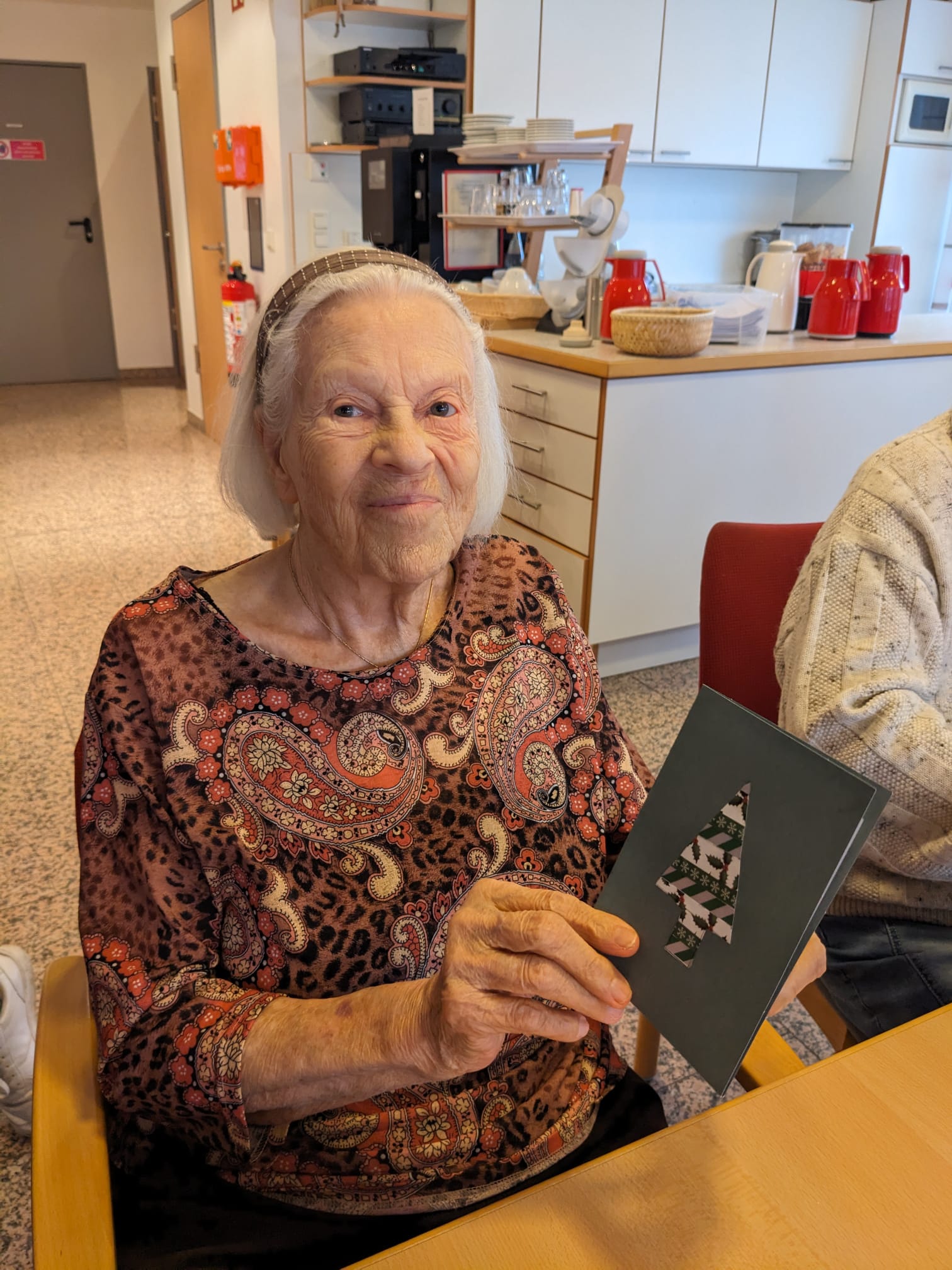 Bewohnerin mit einer Weihnachtskarte in der Hand