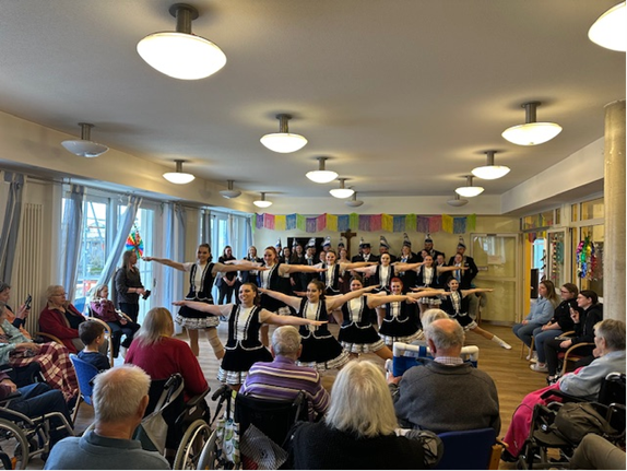 Tänzerinnengruppe vor Senioren