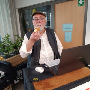 Mann hinter Piano mit Bratwurst in der Hand