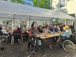 Senioren auf Bierbänken im Freien