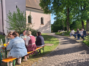 Menschen auf Bierbänken im Freien