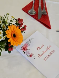 Tischgedeck mit Blumen und Karte